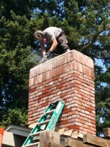 The mason puts the finishing touches on the cap with a grinder.