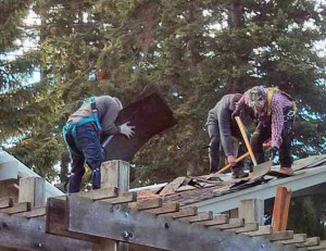 Nearing the front of the house the roofers strip off more old roofing.